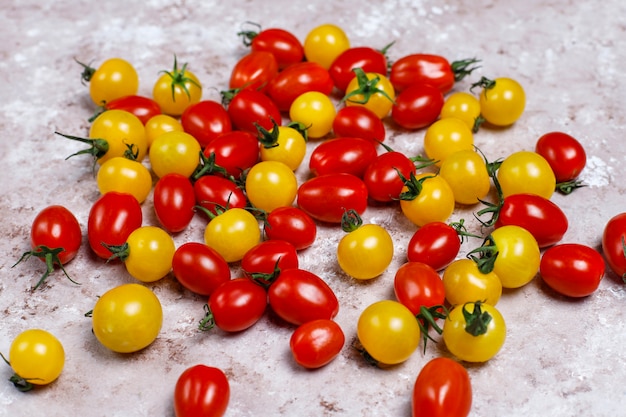 Tomates cerises de différentes couleurs, tomates cerises jaunes et rouges sur fond clair