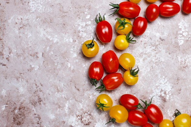 Tomates cerises de différentes couleurs, tomates cerises jaunes et rouges sur fond clair