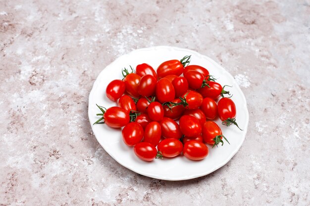 Tomates cerises de différentes couleurs, tomates cerises jaunes et rouges sur fond clair