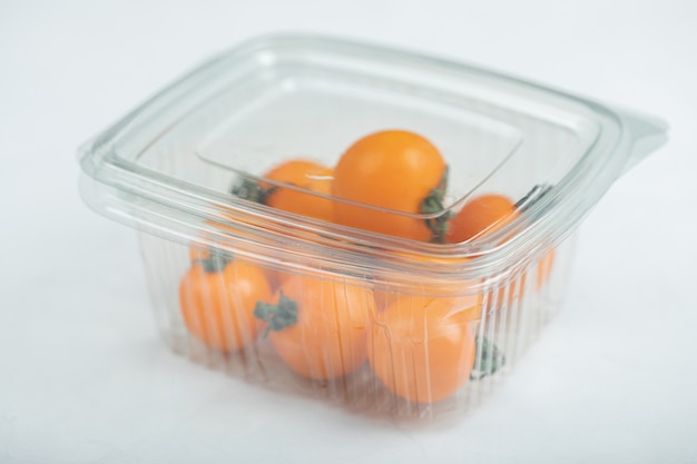 Tomates cerises jaunes dans le récipient en plastique. Photo de haute qualité