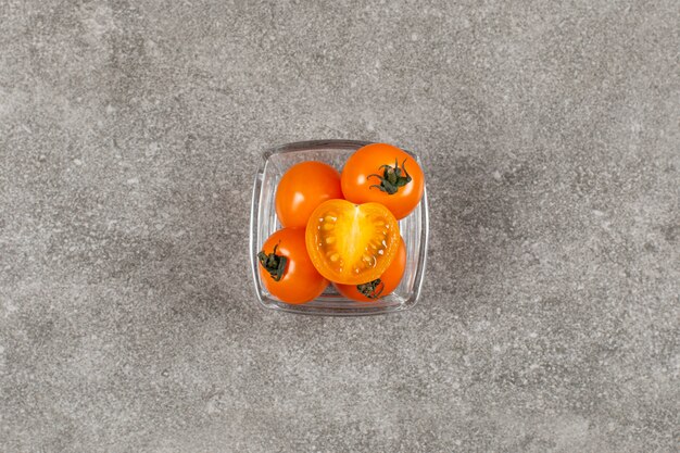 Tomates cerises jaunes fraîches dans un bol en verre.