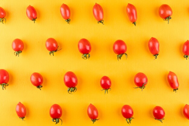 tomates cerises rangées rangée par rangée sur jaune