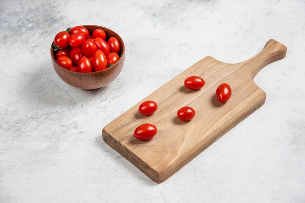 Tomates cerises rouges fraîches sur une planche à découper en bois