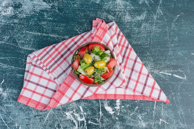 Tomates cerises rouges et jaunes isolées sur une surface bleue.