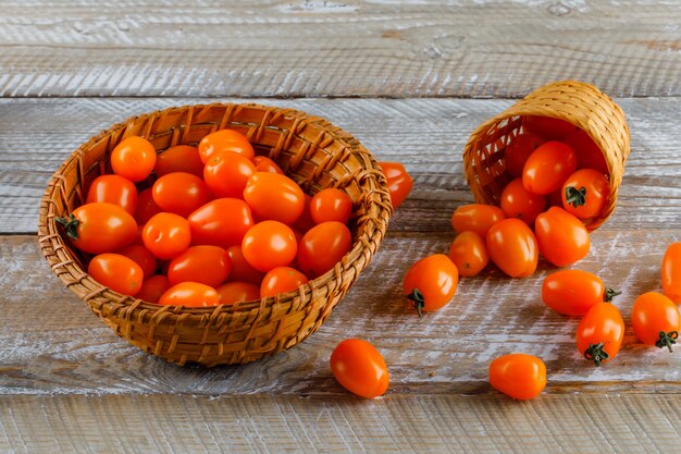 Tomates dans des paniers sur une table en bois. vue grand angle.