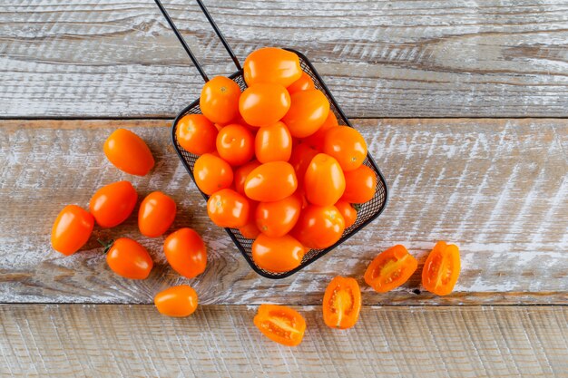 Tomates dans une passoire à plat sur une table en bois