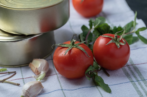 Photo gratuite tomates fraîches à l'ail et aux verts sur une nappe.