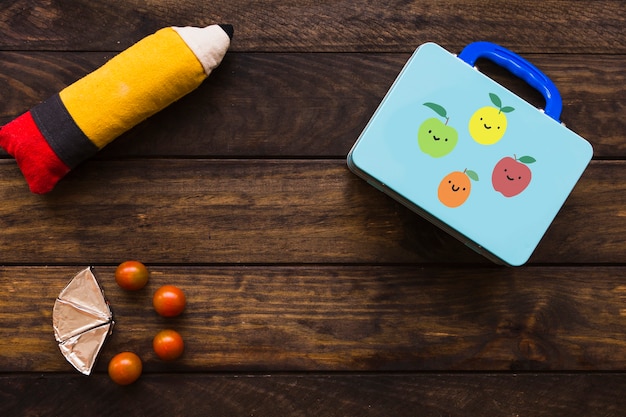 Tomates et fromage fondu près de la boîte à lunch et de l&#39;étui à crayons