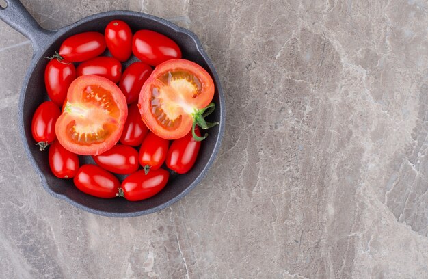 Tomates mûres sur une casserole, sur le marbre.