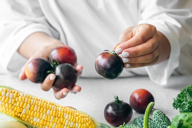 Photo gratuite tomates noires dans les mains des femmes en gros plan cuisine dans la cuisine