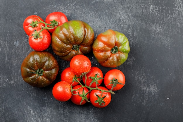 Tomates pluvieuses sur un mur gris grungy. vue de dessus.