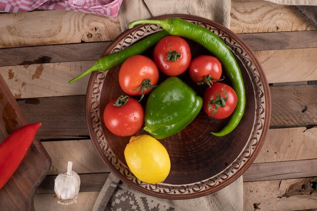 Tomates rouges dans un plat brun avec piment vert et citron