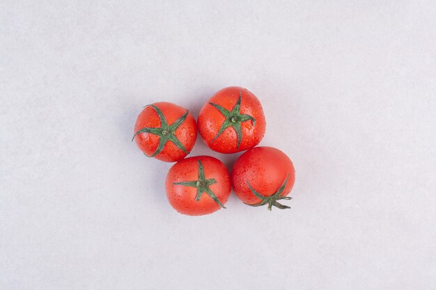 Tomates rouges fraîches sur blanc.