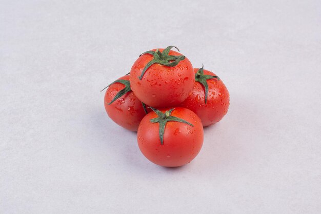Tomates rouges fraîches sur tableau blanc.