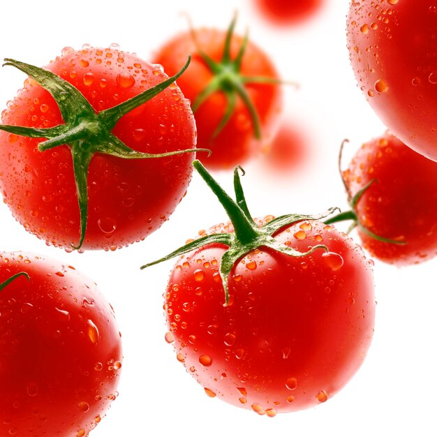 Tomates rouges en lévitation sur fond blanc