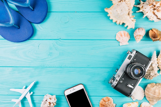 Photo gratuite tongs près de la caméra et des coquillages