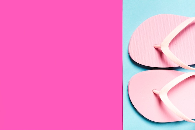 Photo gratuite tongs roses sur une surface colorée