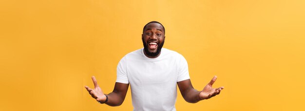Étonné jeune hipster afro-américain portant un t-shirt blanc tenant la main dans un geste surpris