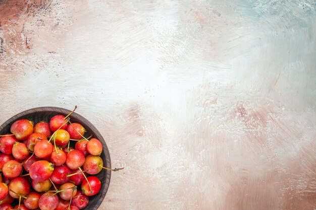 Top close-up view cerises bol brun de cerises sur la table