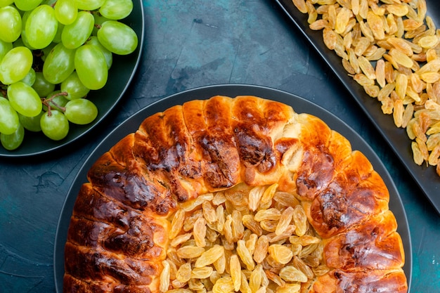 Photo gratuite top close view délicieux gâteau cuit au four avec des raisins verts frais sur le mur bleu foncé gâteau tarte au sucre pâte à biscuits sucrée