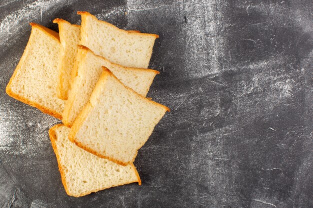 Top close view miches de pain blanc en tranches et savoureux isolés sur le fond gris pâte à pain pain alimentaire