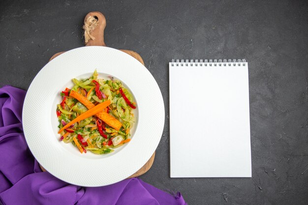 Top salade de légumes vue rapprochée sur la planche à découper le cahier nappe violette