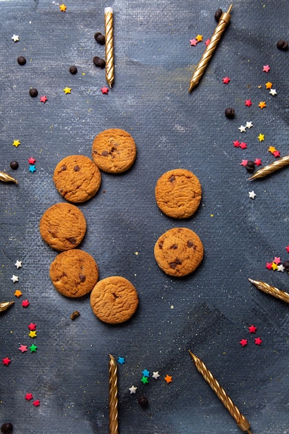 Top vue lointaine délicieux biscuits au chocolat avec des bougies sur le bureau gris foncé biscuit biscuit thé sucré sucre