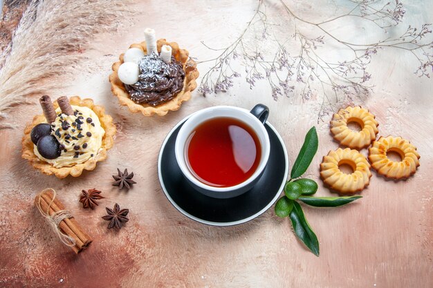 Top vue rapprochée d'une assiette à gâteau de cupcakes biscuits gâteau une tasse de thé