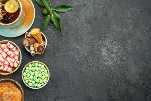 Top vue rapprochée bonbons une tasse de biscuits au thé gaufres bonbons agrumes