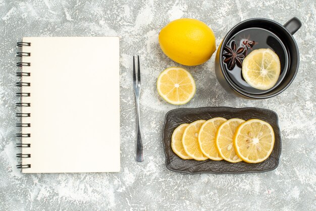 Top vue rapprochée bonbons une tasse de thé avec cahier fourchette citron anis étoilé