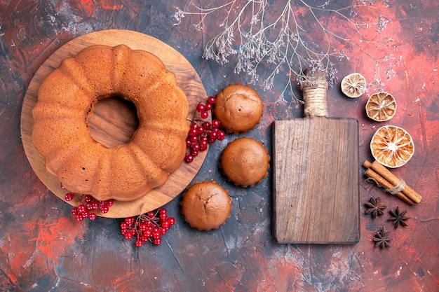 Top vue rapprochée gâteau citron cannelle anis étoilé gâteau en bois avec cupcakes aux groseilles rouges