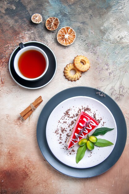 Top vue rapprochée un gâteau une tasse de thé un gâteau avec des sauces biscuits aux agrumes cannelle