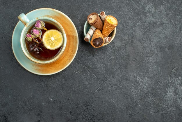 Top vue rapprochée des gaufres bonbons dans un bol une tasse de tisane