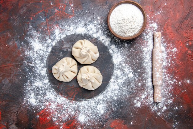 Top vue rapprochée khinkali khinkali farine dans le bol rouleau à pâtisserie