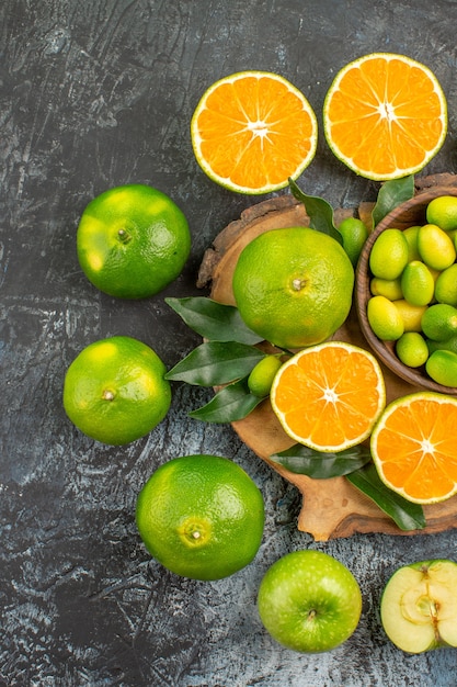 Top vue rapprochée de mandarines d'agrumes autour de la planche à découper avec des agrumes