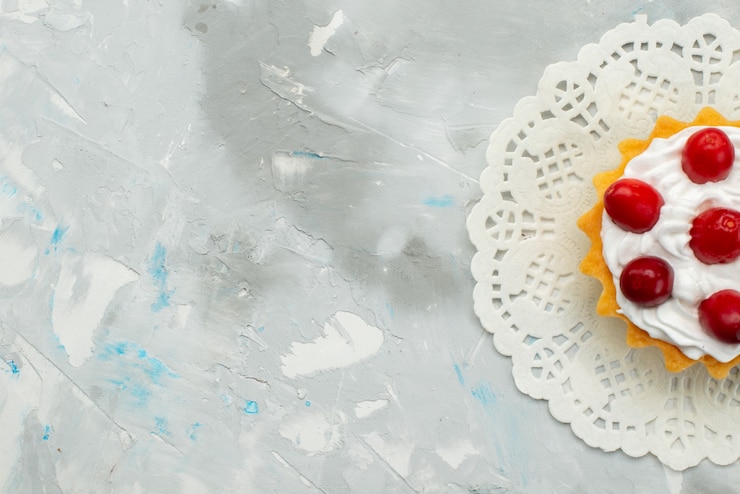 Photo gratuit top vue rapprochée petit gâteau délicieux avec de la crème et des fruits rouges isolés sur la surface légère