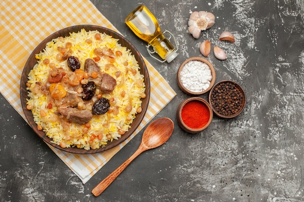 Top vue rapprochée pilaf ail cuillère pilaf sur la nappe bouteille d'huile