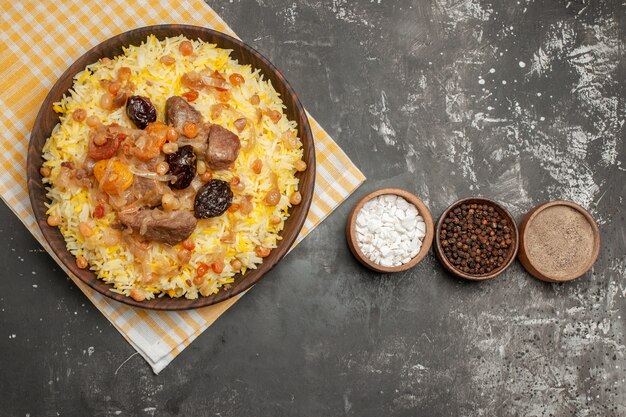 Top vue rapprochée pilaf trois bols d'épices pilaf sur la nappe à carreaux