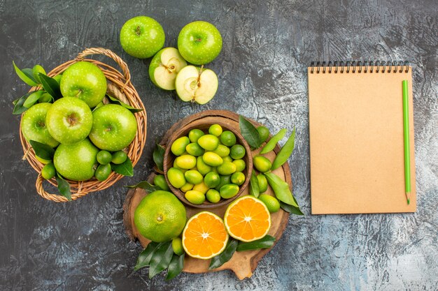 Top vue rapprochée pommes le conseil avec des agrumes panier de pommes crayon de cahier