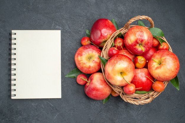 Top vue rapprochée pommes corde pommes cerises dans le cahier de panier