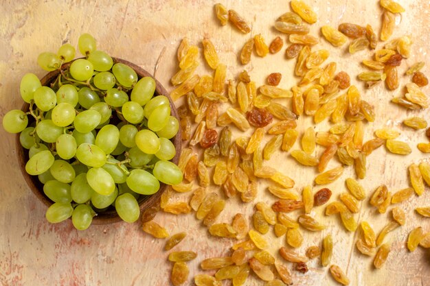 Top vue rapprochée de raisins raisins verts dans le bol et raisins secs
