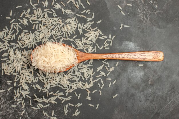 Top vue rapprochée riz riz dans la cuillère en bois sur la table