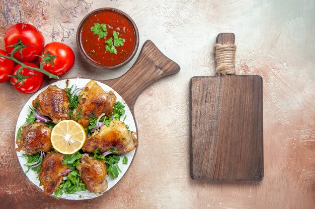 Top vue rapprochée de la sauce au poulet tomates poulet aux herbes de citron sur la planche de bois