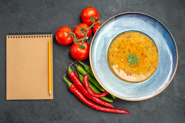 Top vue rapprochée soupe aux lentilles soupe aux lentilles piments forts tomates avec crayon crayon pédicelles