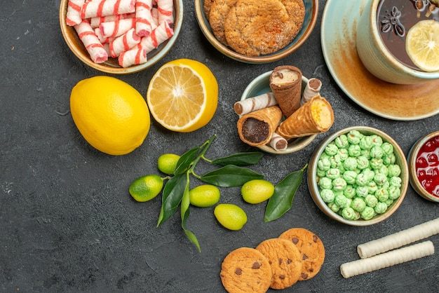 Top vue rapprochée une tasse de thé citron agrumes une tasse de confiture de biscuits bonbons tisane