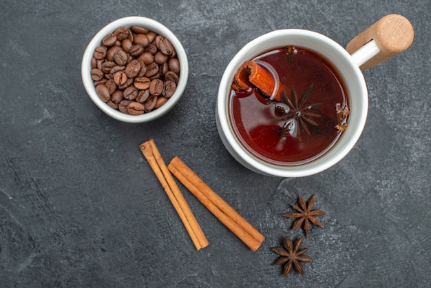 Top vue rapprochée une tasse de thé une tasse de thé bâtons de cannelle anis étoilé grains de café