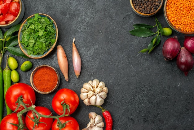 Top vue rapprochée de tomates bol de lentilles oignon poivron noir tomates poivrons épicés herbes herbes