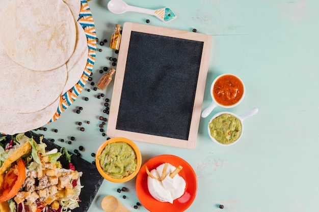 Photo gratuite tortilla et la nourriture mexicaine près de tableau noir