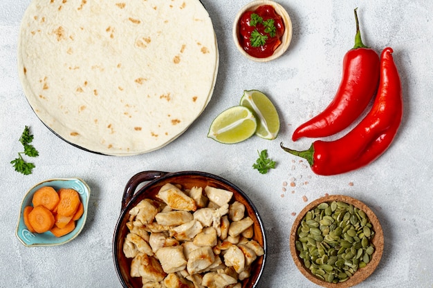 Photo gratuite tortilla et plat de poulet près d'assortiment de légumes