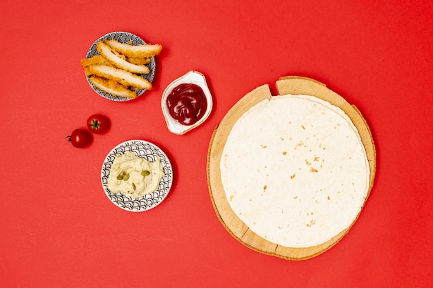 Photo gratuite tortilla ronde avec trempettes à côté du poulet frit